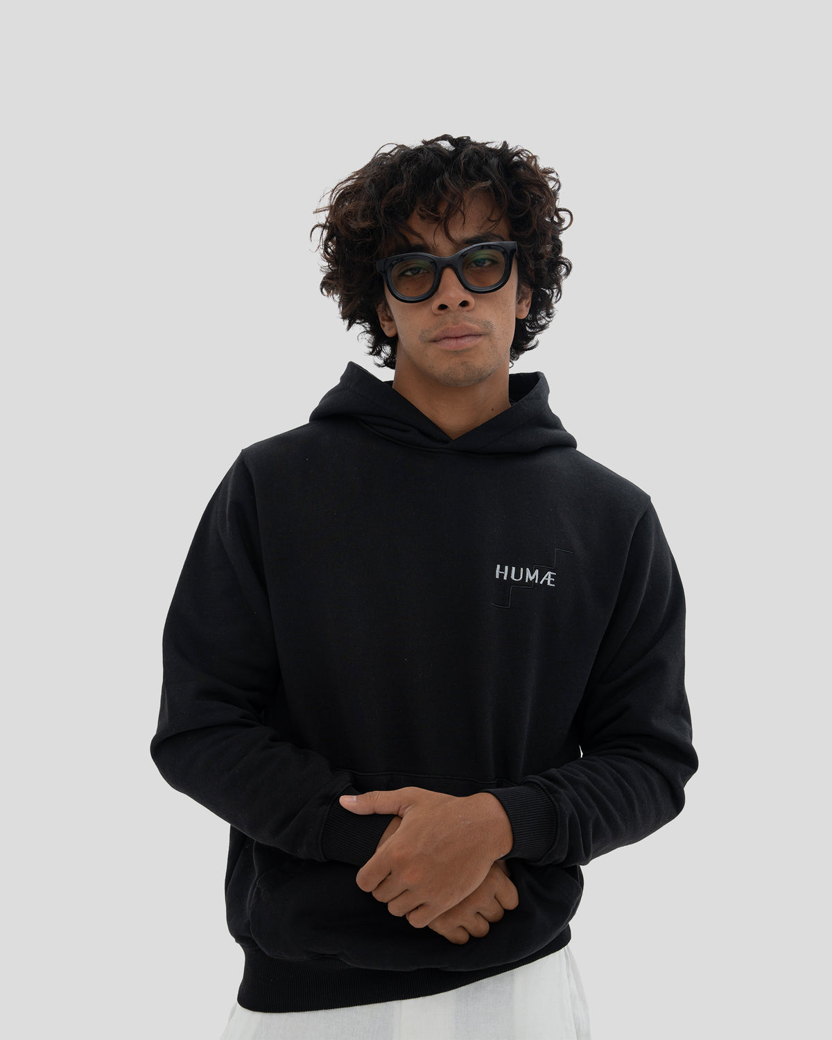 Man wearing the HUMÆ Founder Hoodie in Deep Black, standing in a relaxed front pose