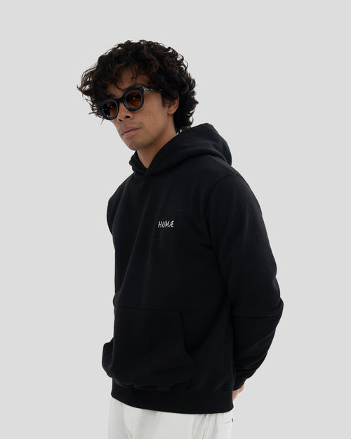 Man wearing the HUMÆ Founder Hoodie in Deep Black, standing in side view.